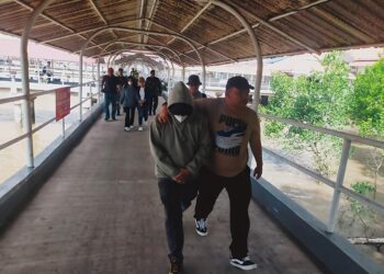 Di Pelabuhan Kota Dumai Minggu (14/9/2025) sekitar pukul 14.50 tampak seorang pria menggunakan Jaket panjang, muka di tutupi masker di duga Mantan Direktur Utama PT SPRH Perseroda bersama seorang wanita juga berpakaian (menggunakan) Jaket muka ditutupi masker sedang di giring oleh Penyidik Kejati Riau.(f: istimewa)