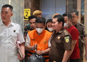 Tangan di gari, Inisial RN menggunakan masker telah memakai baju Oren sambil membawa bungkusan plastik hitam langsung di bawa ke Rutan kelas 1 Pekanbaru (f: Penkum Kejati Riau)