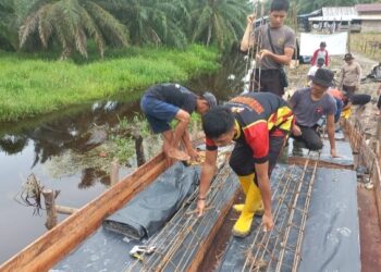 Pemasangan besi cor jembatan merah putih presisi di Kampung Aman (f: Iwandi)